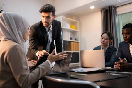 Male boss talking down to women in hijab - Racial Discrimination
